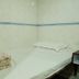Garden Guest House Hong Kong simple single bed with floral bedding in a tiled room