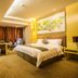 Changchun Huatian Hotel in Changchun guest room with king bed, desk, sofa and warm lighting