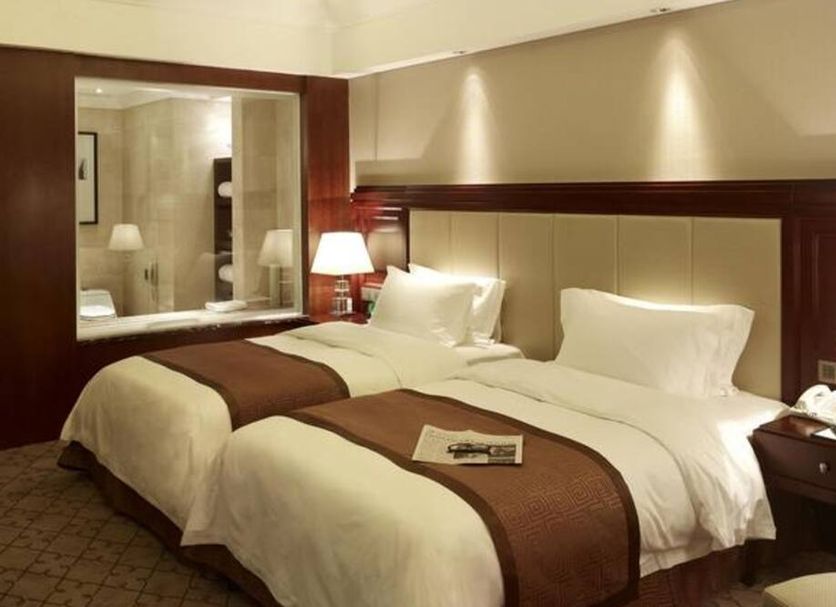 Optics Valley Kingdom Plaza Wuhan guest room with two double beds and bedside lamps in Wuhan