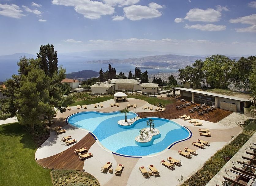 Xenia Palace Portarias in Portaria with a curved outdoor pool, sun loungers, and mountain views