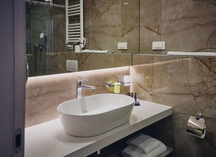 Bathroom vanity at Casino & Hotel ADMIRAL Carnevale Škofije in Koper with vessel sink and large mirror
