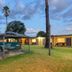 Cootamundra Gardens Motel in Cootamundra with outdoor pool, cabana seating, and palm trees at dusk