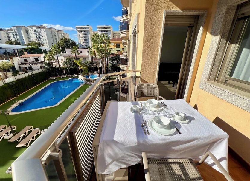 Mediterraneo Real Fuengirola balcony with dining table overlooking pool and gardens