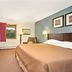 Travelodge by Wyndham Valleyfair Shakopee guest room with king bed, desk, chair, and window view