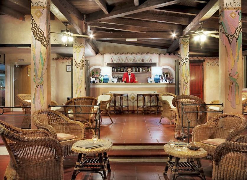 Colonna Beach Hotel Marinella lobby bar with wicker chairs, wooden beams and tiled floor in Golfo Aranci