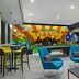 Tru by Hilton Austin Airport lobby with colorful mural, lounge seating and high-top tables in Austin