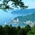 Atami Club Geihinkan in Atami overlooking a coastal bay, forested hills and harbor from above