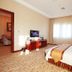 Qilu International Hotel in Harbin guest room with bed, TV, and window with curtains