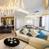 La Vela Saigon Hotel in Ho Chi Minh City luxury suite with chandelier, cream sofa, and dining area