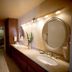 4 Seasons at Desert Breezes Palm Desert bathroom with double vanity, round mirrors and overhead lights