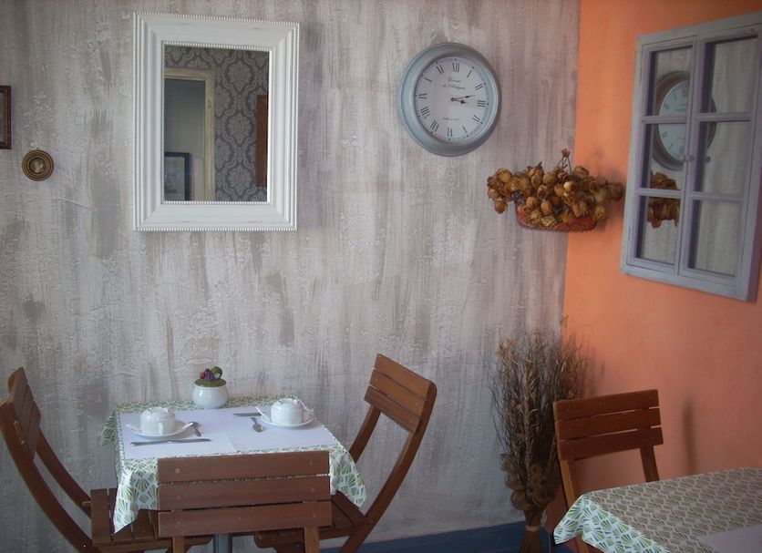 Hotel du Château in Nantes dining nook with wooden table, wall clock, and window mirror