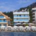 Orsmaris Boutique Hotel in Marmaris beachfront with sun loungers, umbrellas and mountain backdrop