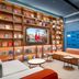 Hanting Hotel Guangzhou Zhongshanba Metro Station lounge with bookshelves, seating, and TV in Guangzhou