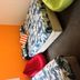 Abel's Central Backpackers in Nelson room with orange wall, patterned beds, and colorful bean bags