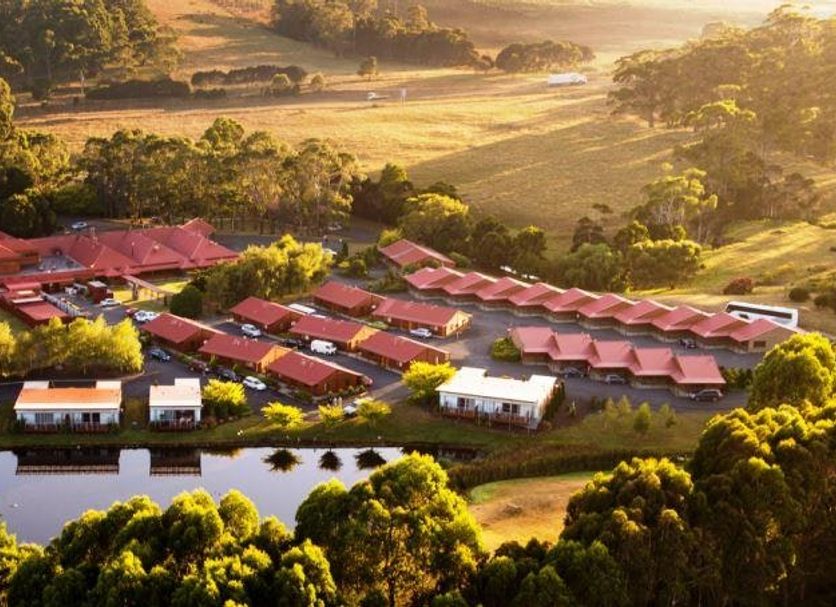 Tall Timbers Tasmania in Smithton, aerial view of red-roofed lodge buildings amid lush greenery