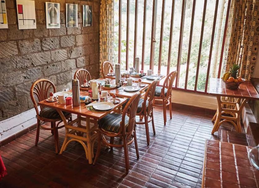 Dining room at Villa Rock Stop Falls Gigiri in Nairobi with set table and large window views