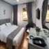 Al-Nujoom Hotel Suites, Amman: compact guest room with double bed, wall-mounted TV, window, and desk