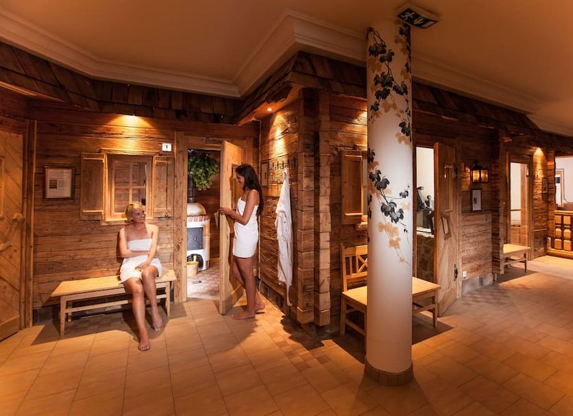Waidringer Hof 4 Sterne Superior spa lounge with wooden saunas and guests in Waidring