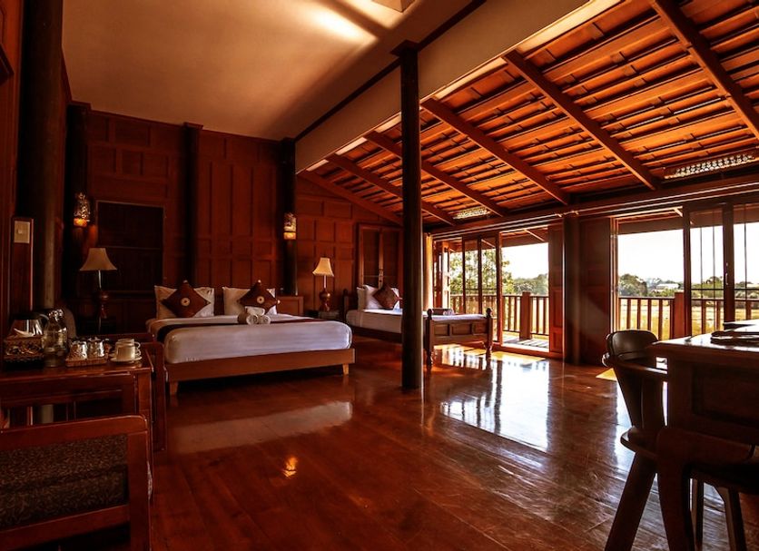 Sasidara Resort Nan guest room with wooden interior, king bed, and open balcony view in Nan