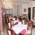 Hotel Chopin in Genoa dining room with tables set with white and pink tablecloths and wooden chairs