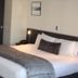 Harvest Lodge in Hastings guest room with king bed, dark accent wall, and open bathroom area