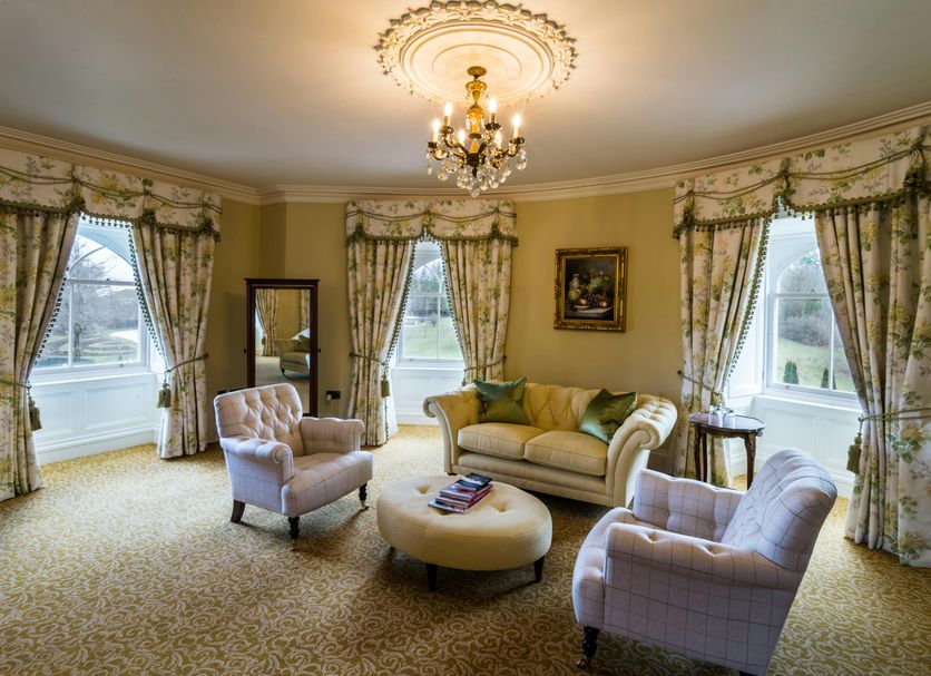 Crossbasket Castle Glasgow sitting room with chandelier, sofas, armchairs and large windows