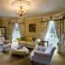 Crossbasket Castle Glasgow sitting room with chandelier, sofas, armchairs and large windows