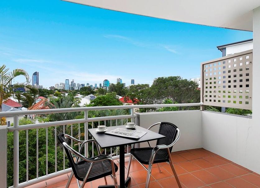 The Wellington Apartment Hotel Brisbane balcony with table, chairs and city skyline view