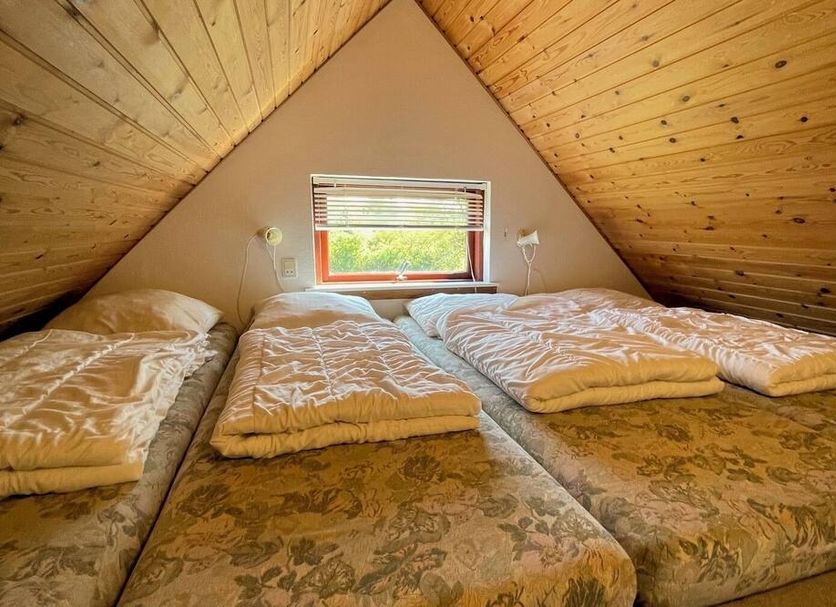 Grindsted Aktiv Camping attic room with three beds and a small window in Grindsted