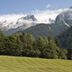 Hotel Pinzolo-Dolomiti in Pinzolo with alpine mountain views above a grassy meadow and forest