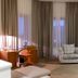 Grand Resort Jermuk in Jermuk guest room with armchair, desk, round table and large curtained windows