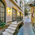 Deniz Inn Boutique Hotel in Baku: cobblestone alley beside arched windows, wall lights, and a small staircase