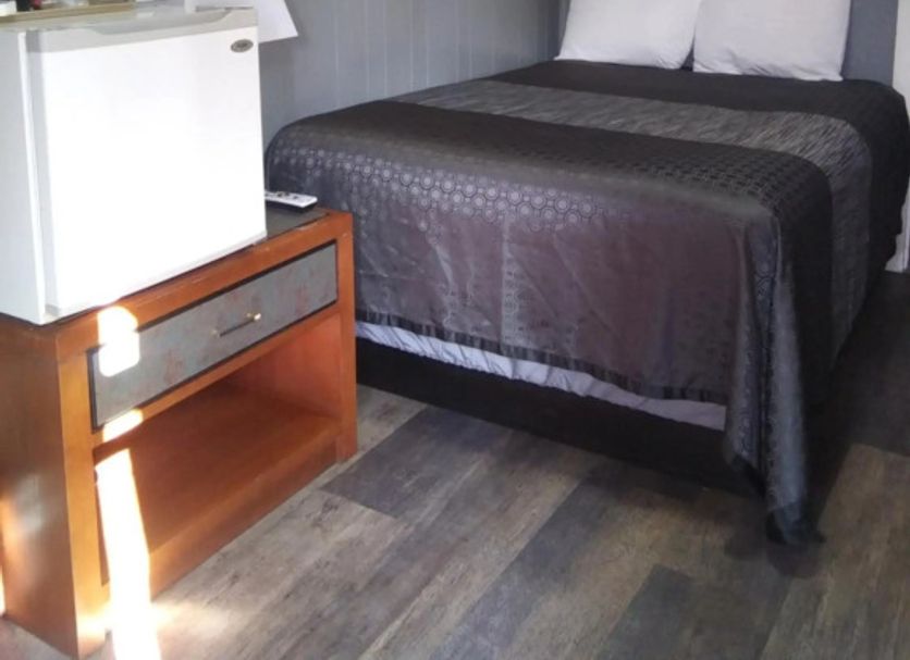 Essex Motel in Alturas guest room with double bed, nightstand, mini fridge and framed wall art