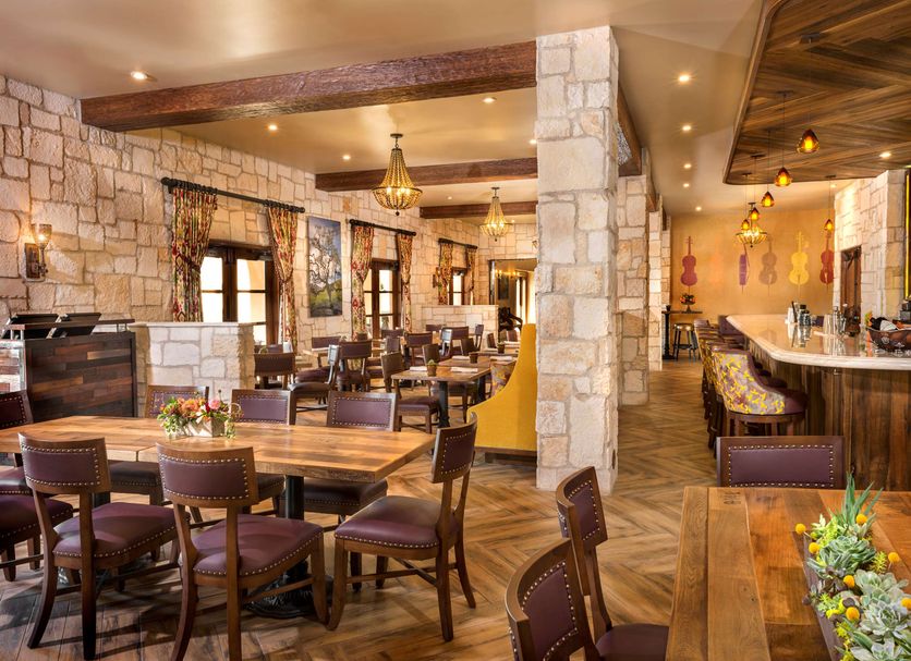 Allegretto Vineyard Resort Paso Robles dining room with stone columns and a bar