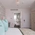 W12 Rooms London guest room with mint pillows, patterned wallpaper, and en suite bathroom doorway