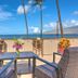 Kohea Kai Hotel Maui in Kīhei ocean-view patio with chairs, table, palm trees, and Maui coastline