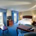 Hampton Inn & Suites Lake Wales guest room with two beds, sofa, TV, and lake view