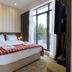 Citrus Hotel Tbilisi guest room with king bed, striped wall, floor-to-ceiling window and balcony view