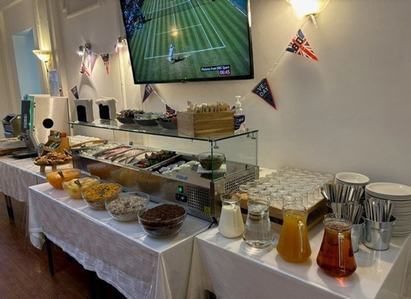 Astor Court Hotel London breakfast buffet with cereal, pastries, juices and wall-mounted TV
