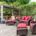 The Stella Rose B&b in Wolfville: outdoor deck with red cushioned wicker seating and lush greenery