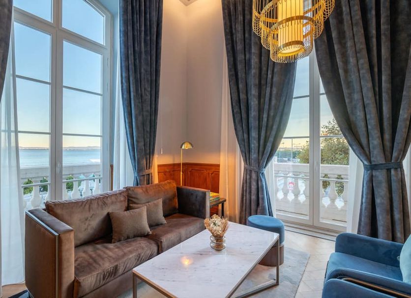 The Editory Riverside Hotel, an Historic Hotel in Lisbon: riverside guest room with tall windows and sofa