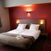 Hotel Villa Monte in Heist op den Berg: double bed room with red accent wall and bedside lamps