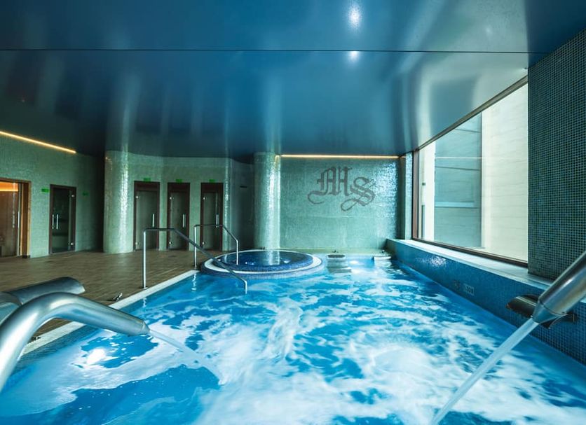 Indoor spa pool at Hotel Mas Solà in Santa Coloma de Farners with blue ceiling and bubbling water