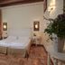Hotel Villa Policreti in Aviano, guest room with double bed, curtains, wall sconces and wood parquet floor