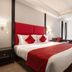 Ramada Encore by Wyndham Jalandhar bedroom with red-accented bed, sofa, desk and window seating