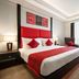 Ramada Encore by Wyndham Jalandhar guest room with king bed, red accents, seating area and city-view window