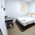 Pinx's Hostel in Jakarta, compact guest room with bed, desk, chair, and open wardrobe