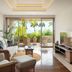 The Ubufuru Ishigaki living room with balcony, wicker seating, and tropical palm view in Ishigaki
