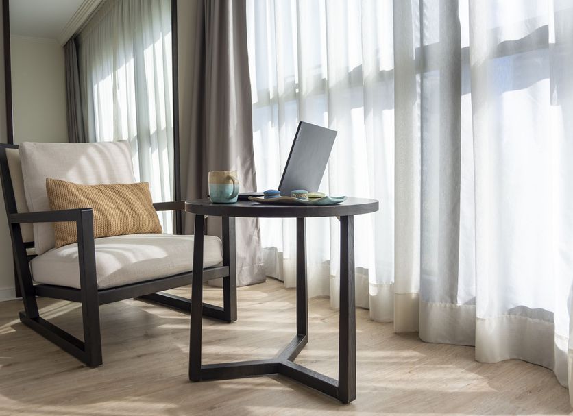 After Hotel Montevideo in Montevideo: bright room with armchair, side table and floor-to-ceiling windows