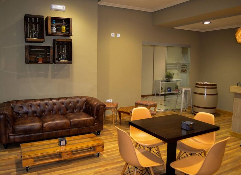 El Retiro de Cardea in Oviedo: lounge with leather sofa, tables, chairs and barrel-style decor